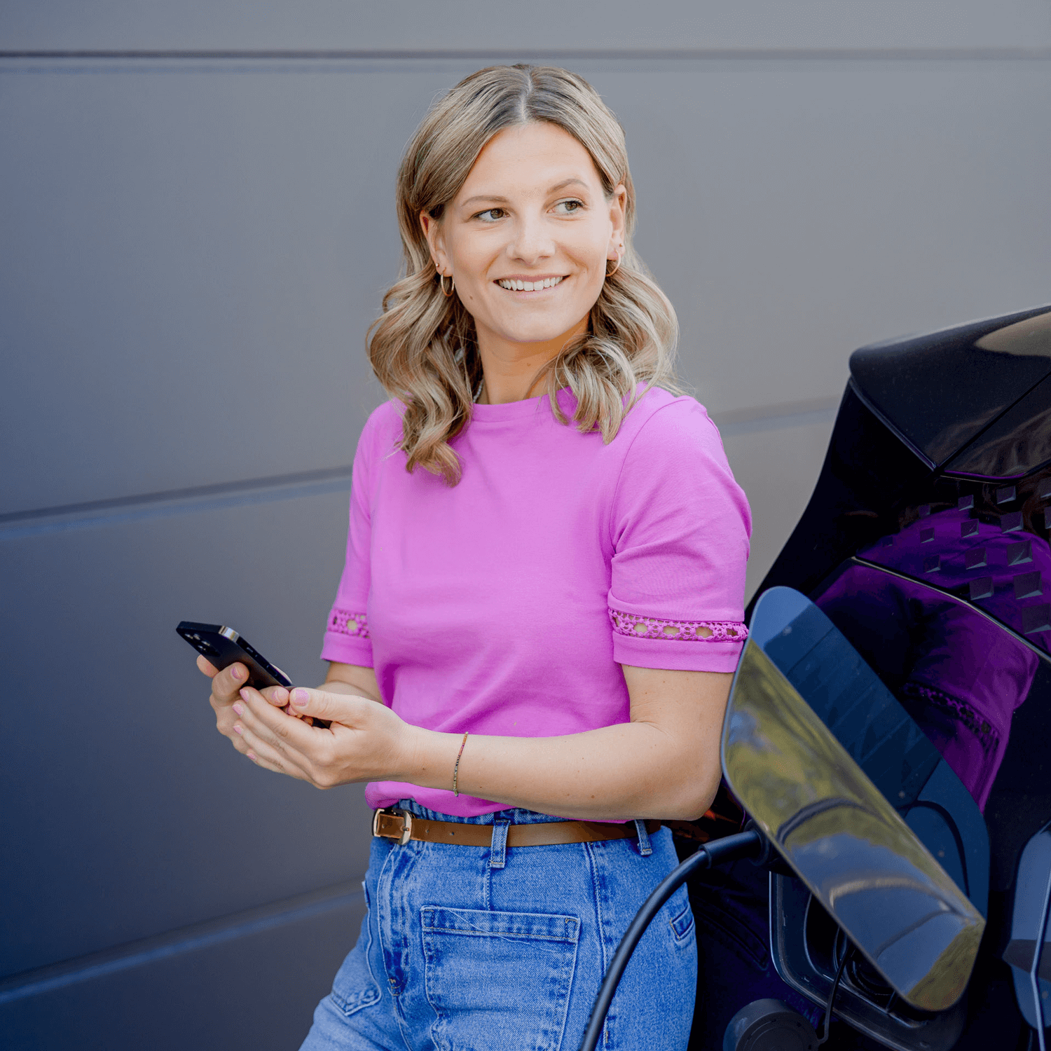 Kundin freut sich ihr Auto mit günstigem Strom zu laden